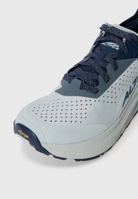 Baskets de course bleu clair avec une tige texturée, des lacets navy et des trous de ventilation. Dotées d'une semelle Vibram robuste pour une adhérence et une durabilité optimales.