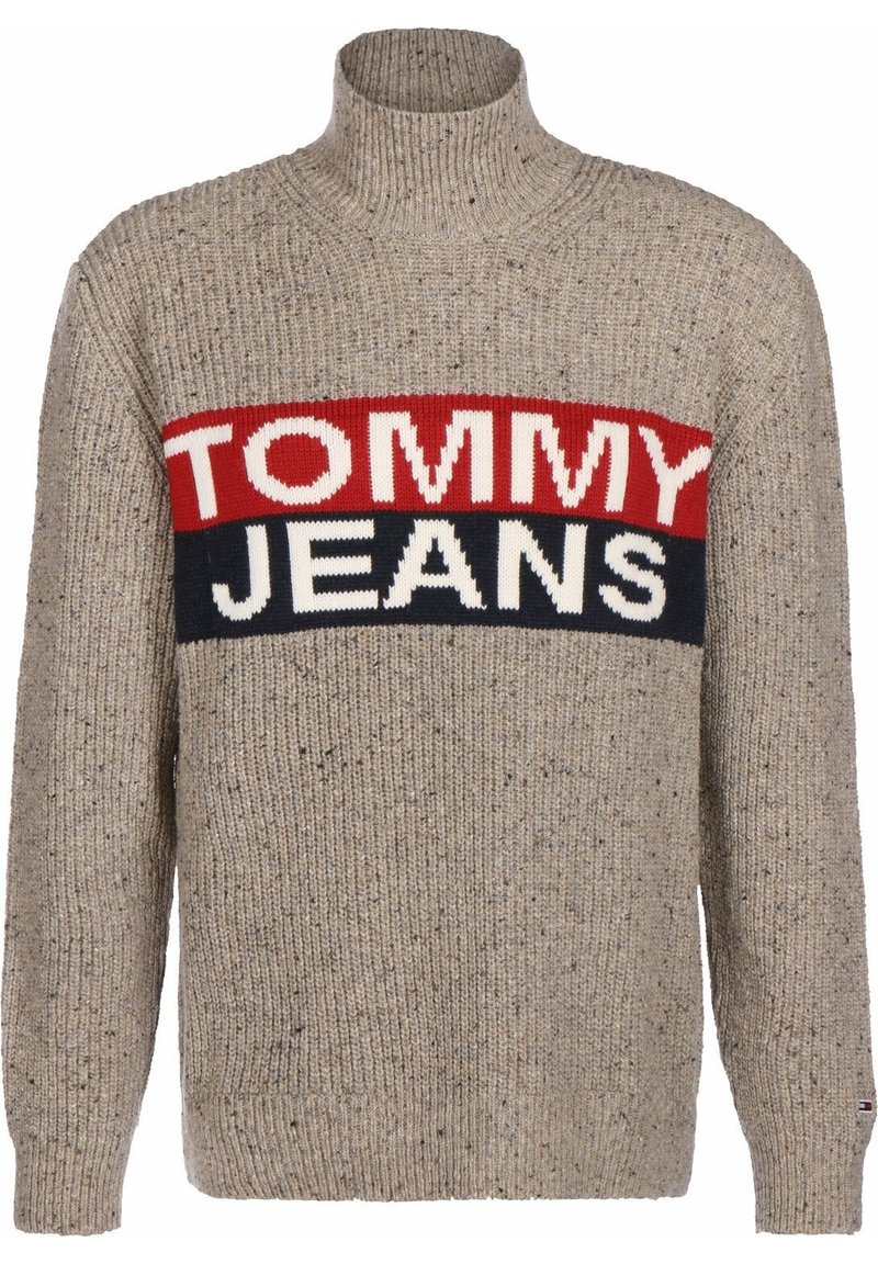 Pull beige avec une texture côtelée, un col haut et un motif à rayures audacieuses comportant "TOMMY" en rouge et "JEANS" en blanc et bleu marine.