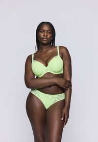 Limoengroene kanten lingerie set met een gepadde bralette met geschulpte randen en bijpassende low-rise slipjes met kanten accenten.