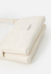 Witte reliëf leren clutch met decoratieve patronen, een gestructureerde vorm en een slank profiel, ontworpen voor draagbaarheid en stijl.