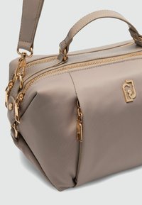 Elegant taupe kabelka vyrobená z hladkého syntetického materiálu, s pozlátenými zipsami a kovovými prvkami, s dvoma hornými uchami a odnímateľným popruhom.