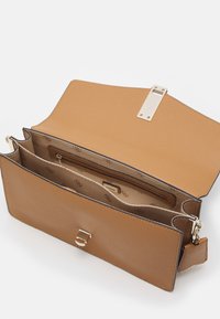 Brązowa skórzana torba z fakturowanym wykończeniem, wyposażona w magnetyczne zapięcie, dwie komory oraz wewnętrzną kieszeń na zamek. Elegancki wzór wnętrza.