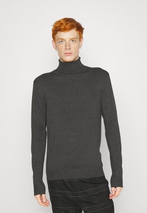 Jersey de cuello alto en gris oscuro, confeccionado en un material de punto suave, que presenta un sutil logo en forma de triángulo en el lado izquierdo del pecho y mangas largas.