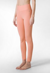 Perziken legging met een hoge tailleband, gemaakt van gladde, rekbare stof. Het ontwerp heeft een naadloze uitstraling en een aansluitende silhouet.