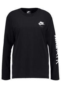 Svart långärmad t-shirt i bomull, med en tryckt vit Nike-logga på bröstet och 'Air' längs den vänstra ärmen.