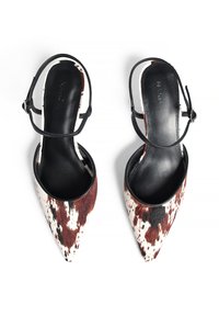 Escarpins slingback à bout pointu en fourrure de vache brun et blanc avec des sangles en cuir noir et un intérieur lisse.