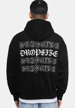 Svart hettegenser med et stort grafisk trykk på baksiden som viser gjentatt tekst "DROPSIZE" i hvit, teksturert skrift, designet med en moderne estetikk.