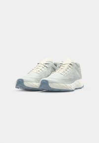 Light gray athletic shoes featuring a textured mesh upper, white laces, and a blue rubber sole with a streamlined design.