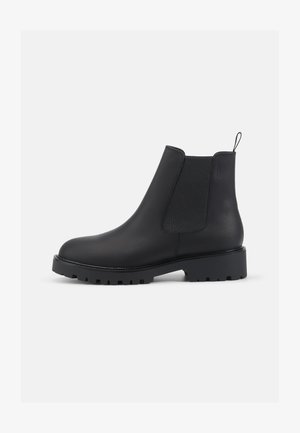 Mustad mustad Chelsea-kingad elastsete külgpaneelidega, ümar nina, tõmbeaas ja vastupidav profiilne tall, mis tagab haarde. Sile tekstuur ja stiilne disain.