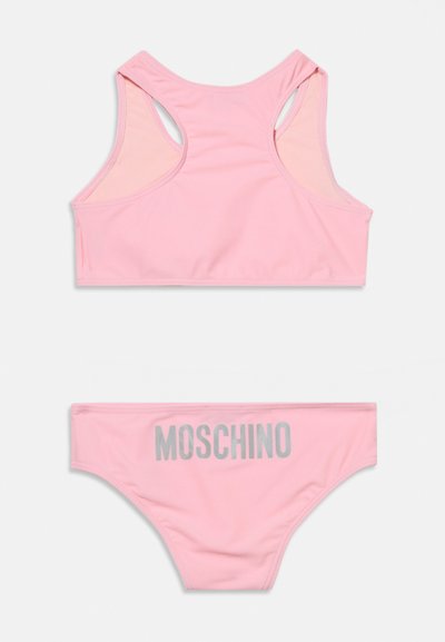 Ροζ ανοιχτό ροζ μαγιό δύο τεμαχίων με τοπ racerback και σλιπ με γκρι γράμματα "MOSCHINO" στο πίσω μέρος.