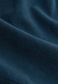 Tela azul oscuro con una superficie suave y ligeramente texturizada, mostrando pliegues y sombras suaves.