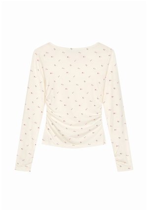 Cremefarvet langærmet top med lille rødt blomsterprint, indsamlede sidesømme og en bred, rundet halsudskæring.