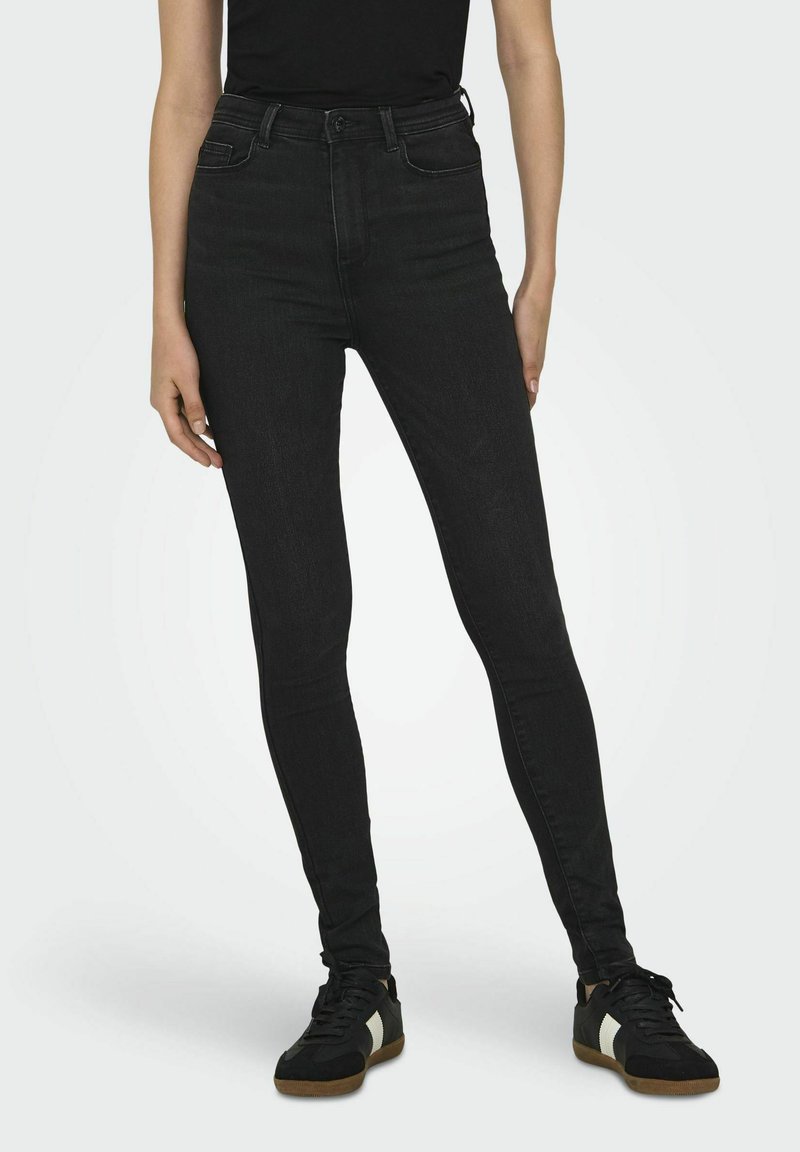 Pantalones vaqueros negros de tiro alto con corte slim y un ligero estiramiento. Cuenta con cinco bolsillos, trabillas para el cinturón y una textura suave y mate.