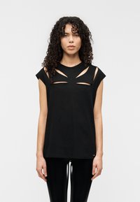 Μαύρο βαμβακερό αμάνικο τοπ με κοψίματα στους ώμους και το στήθος, με στρογγυλή λαιμόκοψη και άνετη εφαρμογή, σε συνδυασμό με γυαλιστερά κολάν.