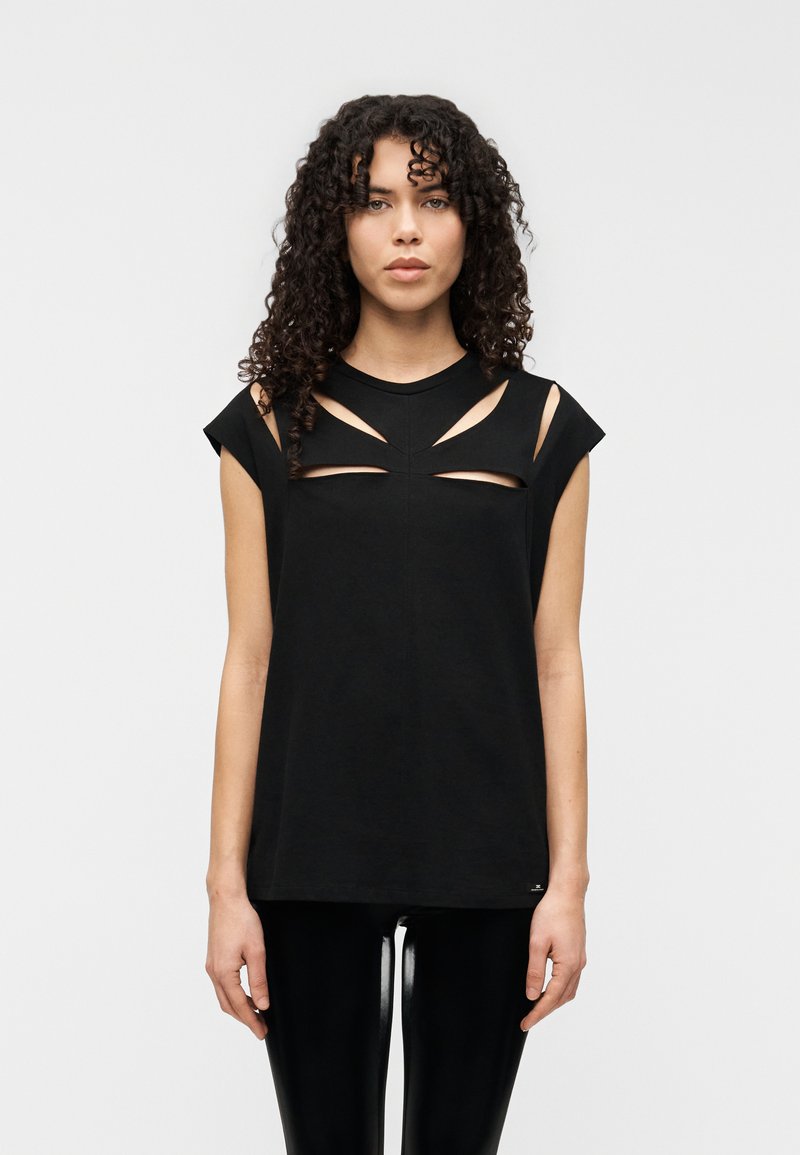 Μαύρο βαμβακερό αμάνικο τοπ με κοψίματα στους ώμους και το στήθος, με στρογγυλή λαιμόκοψη και άνετη εφαρμογή, σε συνδυασμό με γυαλιστερά κολάν.