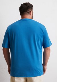 Blauwe T-shirt met korte mouwen, gemaakt van zachte stof, met een relaxed fit en een ronde halslijn. Glad textuur zonder zichtbare patronen.
