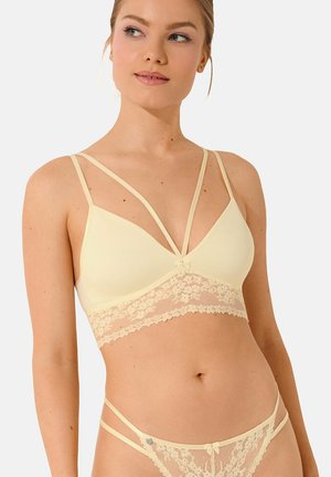 Lichtgele bralette met kantafwerking, met een dunne spaghettibandjesdesign, en een klein strikdetail in het midden. Bijpassende kantstring inbegrepen.