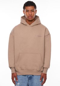 Hoodie beige en mélange de coton, doté d'une poche frontale, de poignets côtelés et du mot "Dropsie" brodé dans une tonalité subtile.