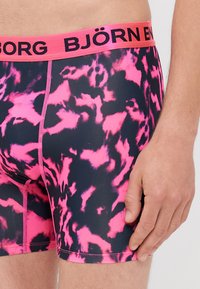 Fekete és rózsaszín absztrakt mintázatú boxeralsó, élénk rózsaszín derékpánttal, rajta "BJÖRN" felirattal és kontrasztos varrási részletekkel.