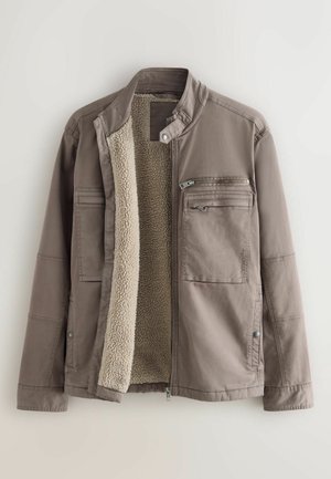 Brown outer jacket with a faux fur lining. Features multiple pockets: one zippered and two flap pockets. Snap closure and stand collar.