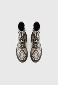 Schlange-Muster Stiefeletten mit schwarzen Schnürsenkeln und Gummisohlen. Verfügt über einen Reißverschluss und eine strukturierte Oberfläche. Überwiegend beige und schwarze Farben.