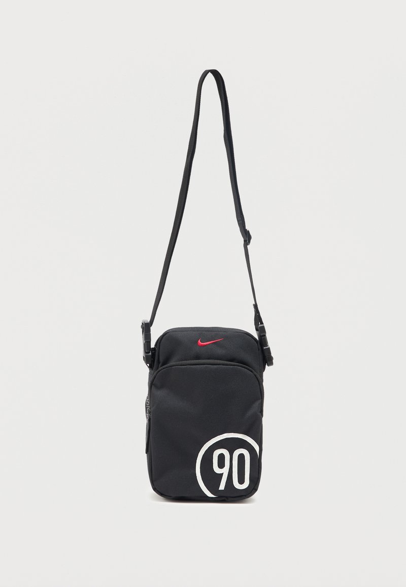 Μαύρη τσάντα Nike χιαστί με ρυθμιζόμενο ιμάντα, κόκκινο λογότυπο Swoosh κοντά στην κορυφή και λευκό τύπωμα "90" σε κύκλο κάτω δεξιά.