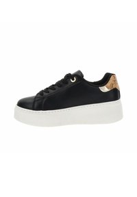 Zapatilla de cuero negra con suela de plataforma blanca, que presenta ojales dorados y un acento texturizado en dorado y beige en el talón.