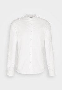 Chemise blanche à manches longues avec col mandarin, coupe slim et poignets, sur un fond clair uni.