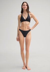 Schwarzes Bikiniset mit einem Halterneck-Oberteil im dreieckigen Design und passenden, tief geschnittenen Unterteilen; strukturierter Musterverlauf.