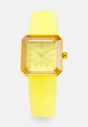 Yellow square-faced wristwatch with gold frame, yellow hands, and a smooth yellow strap, showing time at 10:10.