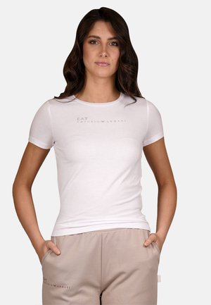 T-shirt bianca aderente con maniche corte. Presenta un sottile logo EA7 Emporio Armani in grigio chiaro. Tessuto di cotone morbido, consistenza liscia.