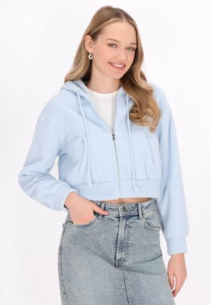 Helleblaue, kurz geschnittene Kapuzenjacke mit Reißverschluss aus strukturiertem Fleece, mit Kordeln und Vordertaschen, kombiniert mit einem hoch taillierten Jeansrock.