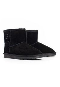 Botines de ante negro con punta redonda, panel lateral texturizado con tachuelas decorativas y suela de goma. Forro suave visible en la parte superior.