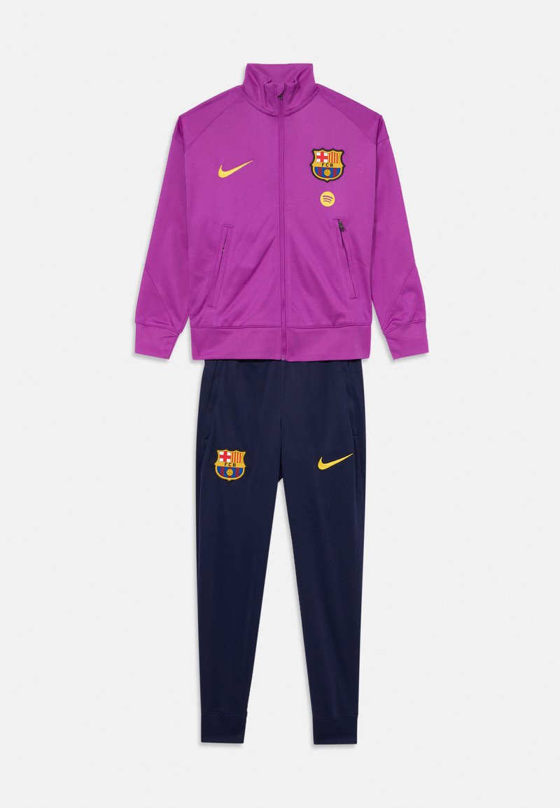 FC Barcelona sporta kostīms ar purpura krāsā apģērbtību ar zilu rāvējslēdzēja jaku un ziliem biksēm. Materiāls: poliesters. Akcenti ietver komandas logotipu un Nike swoosh dzeltenā krāsā.