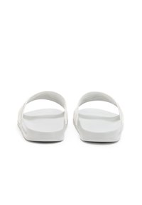 Sandali bianchi open-toe con texture liscia, suola piatta e doppie cinghie superiori per il supporto del piede. Design minimalista, senza ulteriori dettagli.