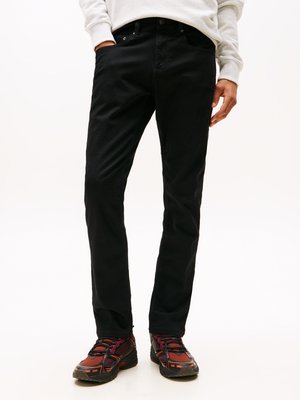 Zwarte, slim-fit broek met een gladde textuur en vijf zakken, gecombineerd met meerkleurige, gestructureerde sportschoenen.