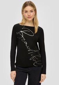Czarna koszulka z długim rękawem, wykonana z gładkiego materiału, z metalicznym srebrnym napisem "Piękna" po przekątnej z przodu.