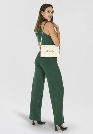 Sac bandoulière blanc avec quincaillerie dorée et logo 'GUESS', en cuir lisse, de forme rectangulaire et avec une bandoulière réglable.