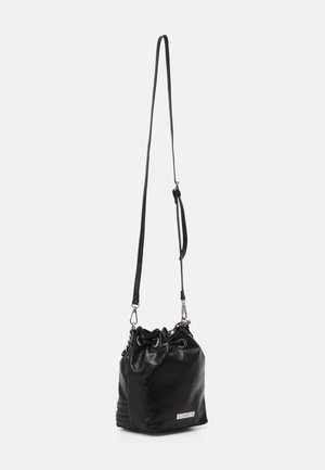 Czarna skórzana torba typu bucket z zaciąganym zamknięciem i długim regulowanym paskiem na ramię zawieszona na białym tle.