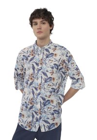 Camicia a maniche corte in lino bianco con un motivo floreale blu e marrone, caratterizzata da un colletto band e dettagli con maniche arrotolate.