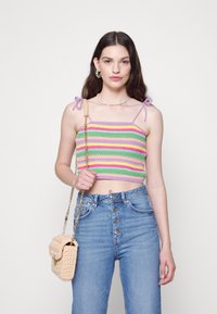 Top cropped em crochet com listras pastel em roxo, rosa, verde e amarelo. Apresenta alças ajustáveis no ombro. Combinado com jeans de cintura alta azuis.