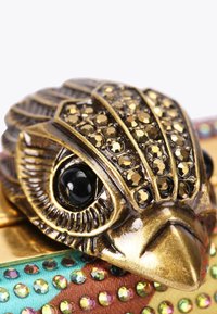 Clutch in metallo con una chiusura a forma di gufo. Finitura in tono oro con accenti di pietre nere e strass colorati su una base in tessuto testurizzato.