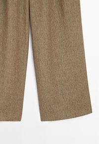 Hnědé lněné kalhoty s širokými nohavicemi a texturovaným povrchem, které mají volný střih a rovné nohavice. Vhodné pro každodenní nošení i formální příležitosti.