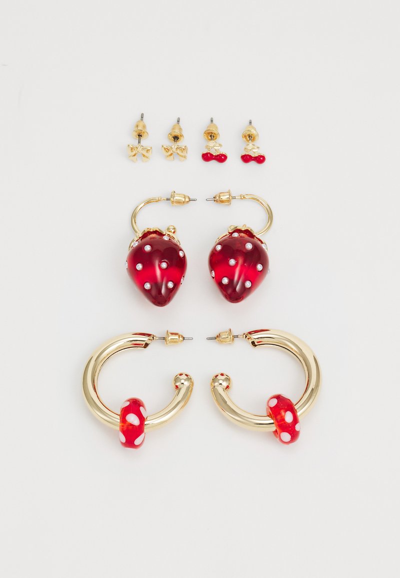Red strawberry-shaped earrings with gold hardware, embellished with white dots, alongside gold stud earrings featuring bow and cherry designs.