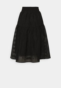 Jupe noire à volants fabriquée dans un tissu texturé avec un motif en grille. Elle est dotée d'une taille élastique et d'une silhouette fluide.