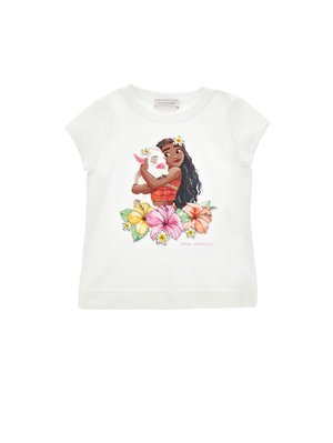 Dziewczyna z długimi ciemnymi włosami przytula uśmiechnięte prosię, otoczone kolorowymi kwiatami hibiskusa na białej koszulce z krótkim rękawem.
