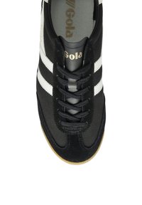 Black athletic shoe with white stripes, featuring a canvas and suede upper, round toe, and flat laces. Gola logo in gold on tongue.