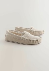 Beige stoffen slippers met een gestructureerd oppervlak, voorzien van een gezellige faux fur voering en decoratieve stiksels langs de randen.