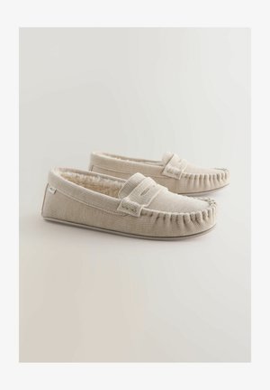 Béžové textilné papuče s textúrovaným povrchom, s útulným umelým kožúškom a dekoratívnym prešitím pozdĺž okrajov.