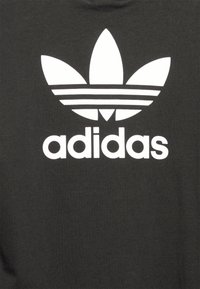 Haut à capuche noir en coton avec un grand logo Adidas blanc comprenant un design à trois feuilles et des rayures horizontales sous le nom de la marque.